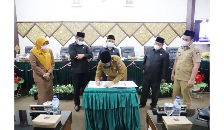 TANDA TANGAN— Wako Padang Hendri Septa menandatangani persetujuan Ranperda Perubahan Atas Perda Nomor 6 Tahun 2019 Tentang RPJMD Kota Padang tahun 2019-2024 dalam sidang paripurna, Senin (6/12) malam.