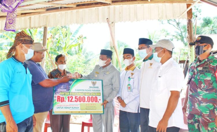 Wakil Bupati Padangpariaman Rahmang menyerahkan dana bantuan bedah rumah tidak layak huni dari Badan Amil Zakat Nasional (Baznas) Kabupaten Padangpariaman kepada keluarga Zainul di Korong Kampung Apar Nagari Sungai Buluah Utara Kecamatan Batang Anai.