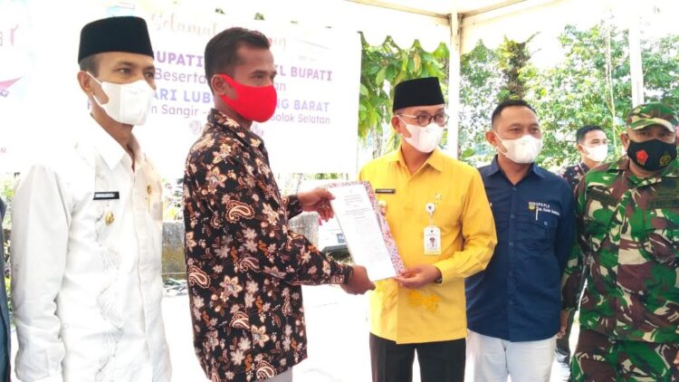 Bupati Solsel, Khairunas didampingi Wakil Bupati, Yulian Efi menyerahkan bantuan bedah rumah kepada penerima secara simbolis