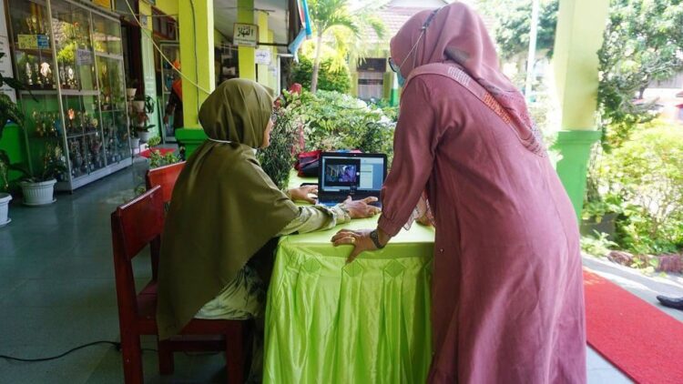 APLIKASI E-TAMU— Seorang  guru saat melihatkan  aplikasi e-Tamu.