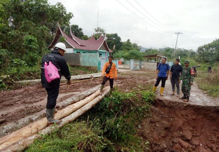 PERSIAPKAN JEMBATAN DARURAT—Tim gabungan mempersiapkan jembatan darurat karena jalan putus.