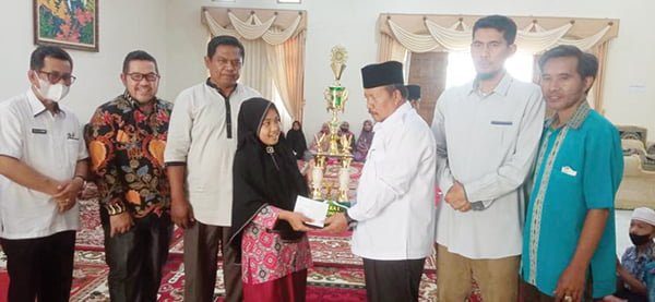 SERAHKAN HADIAH— Bupati Agam Andri Warman menyerahkan hadiah kepada juara lomba MTQ Online II.