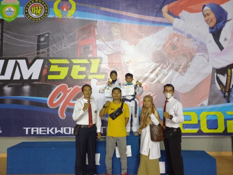 NAIK PODIUM— Dua taekwondo Sumbar Dafa dan Khanza usai upacara penghargaan pemenang bersama pelatih dan orang tuanya pada Kejuaraan Taekwondo Sumsel Open 2022.