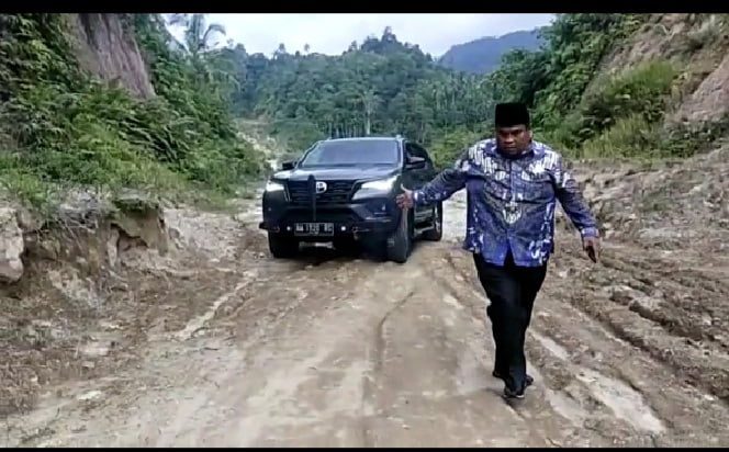 JALAN LINGKAR—Bbupati Padangpariaman Suhatri Bur  menuju Masjid Korong Hilang Gadang, harus turun mobil di jalan lingkar.