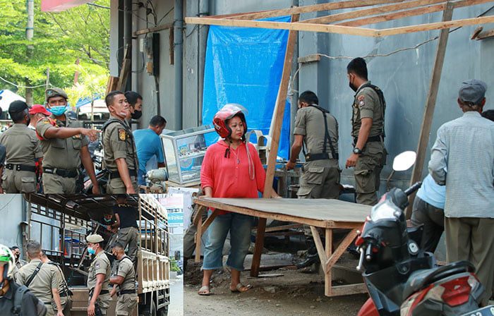 PENATAAN— Petugas Satpol PP Kota Padang mengangkut sejumlah lapak-lapak milik PKL yang berada di sisi kiri dan kanan jalan di samping pertokoan Kompleks Atom Center, Selasa (4/1).