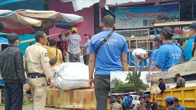 LAPAK DAN BARANG DIAMANKAN— Petugas gabungan Disdag dan Satpol PP Kota Padang, membawa barang dagangan pedagang ke atas mobil truk saat dilakukan penertiban di tiga lokasi, jalan Sandang Pangan, Pasar Raya Barat dan Permindo, Rabu (26/1).