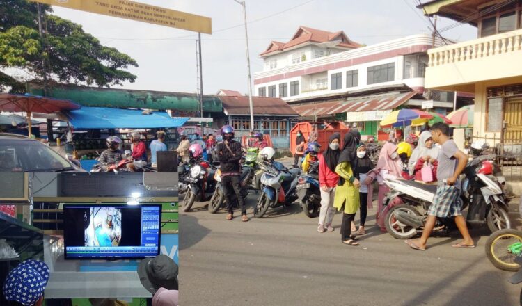 MOTOR RAIB— Korban Dewi Mandasari (33) dibantu pemilik toko memeriksa rekaman CCTV untuk mencari petunjuk terkait hilangnya sepeda motor di parkiran Pasar Jorong Jati.