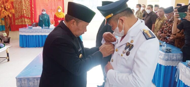 PEMASANGAN PIN— Bupati Agam, Dr. H. Andri Warman memasangkan pin atau bonggol kepada Camat Palupuah Zulfikar Zulkifli saat acara pelantikan dan sertijab dengan pejabat lama di Aula Kantor Camat Palupuah, Sabtu (1/1).
