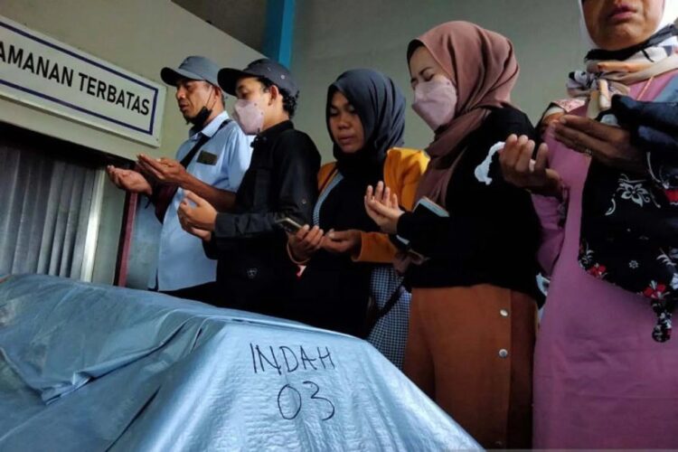 BERDOA— Keluarga berdoa di samping peti jenazah DJ Indah Cleo, salah satu korban aksi pembakaran karaoke di Kota Sorong, Minggu (30/1).