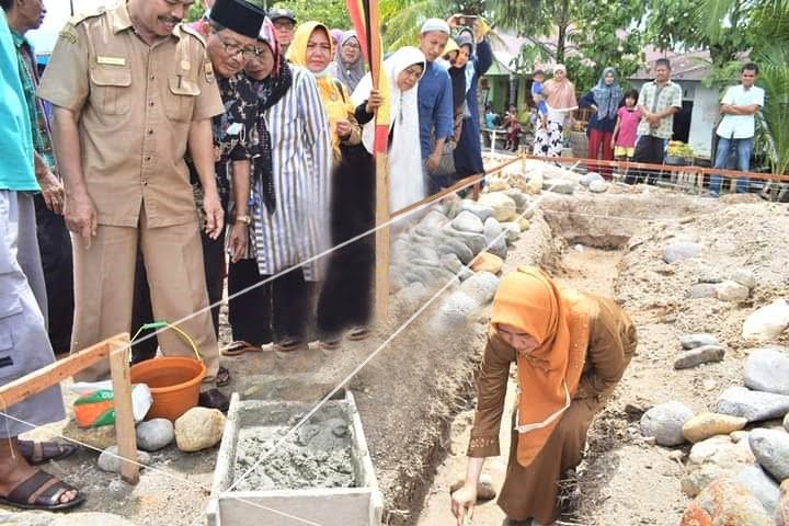 BATU PERTAMA—Ketua TP PKK Kota Pariaman, Ny. Lucyanel Genius meletakkan batu pertama tanda dimulainya pembangunan mushalla.