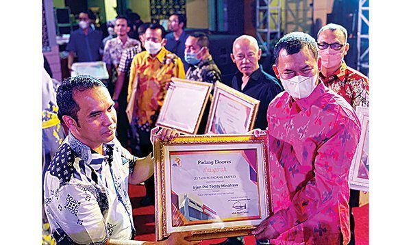 TERIMA PENGHARGAAN— Kabid Humas Kombes Pol Satake Bayu mewakili Kapolda Sumbar menerima penghargaan Tokoh Percepatan Vaksinasi dari Direktur Padang Ekspres M Nazir Fahmi.