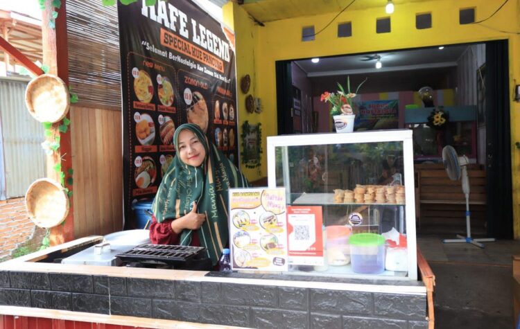 Perjuangan Donna, Pelaku UMKM Penjual Kue Pancung Bertopping 1 LAYANI— Dona disela-sela melayani pelanggan yang datang menyempatkan diri berfoto di depan usahanya.