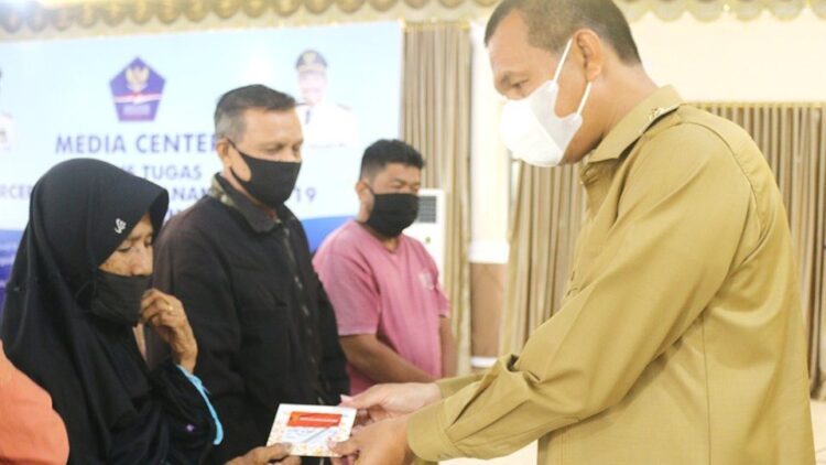 SERAHKAN KARTU—Wali Kota Pariaman Genius Umar   serahkan kartu PPKM tahap II kepada masyarakat.