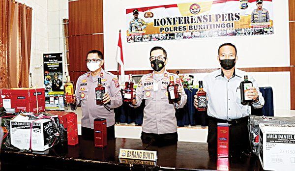 MIRAS ILEGAL— Kapolres Bukittinggi AKBP Dody didampingi Wakapolres dan Kasatresnarkoba memperlihatkan barang bukti miras ilegal hasil tangkapan.