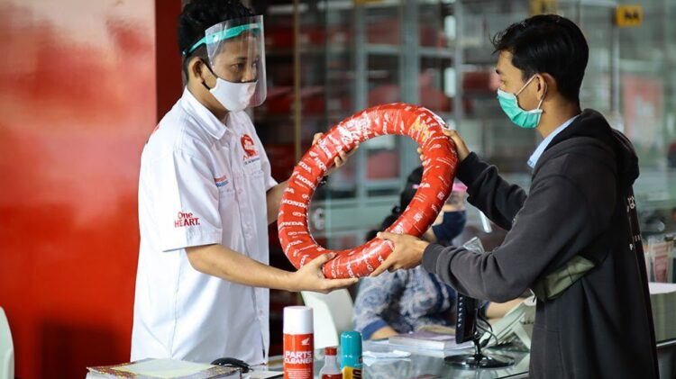 BELI BAN-Karyawan PT Menara Agung melayani konsumen yang melakukan pembelian ban Honda Genuine Tire.