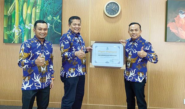 PIAGAM PENGHARGAAN— (Ki-Ka) Ferdi Firmansyah Pemimpin Bagian Administrasi dan Pelaporan Divisi Kredit dan Mikro Banking, Sukardi Pemimpin Divisi Kredit dan Mikro Banking, Gusti Candra Direktur Kredit dan Syariah memerlihatkan piagam.