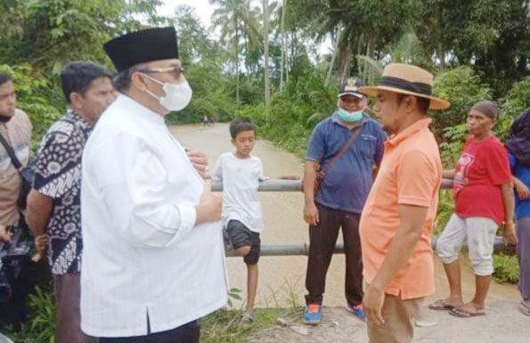 BERDIALOG— Bupati Pasaman Benny Utama saat berbincang-bincang dengan salah seorang tokoh masyarakat di lokasi bencana banjir.