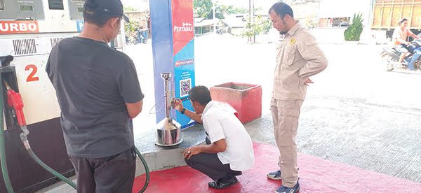 PEMERIKSAAN ALAT UKUR— Petugas UPTD Metrologi Legal Kabupaten Agam melakukan penertiban alat ukur di SPBU kawasan Manggopoh, Sabtu (13/2) siang. Hal ini dilakukan untuk menghindari kemungkinan terjadinya kecurangan alat takar yang dapat merugikan konsumen.