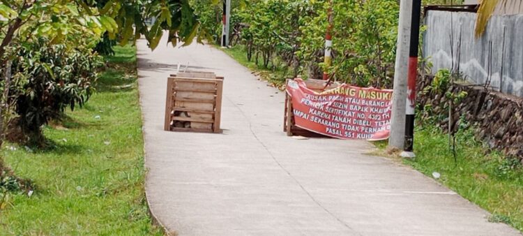 DILARANG MASUK--Jalan akses masuk ke komplek PPLP Dispora Sumbar di Sungai Sapih Kuranji diportal dengan spanduk dilarang masuk.