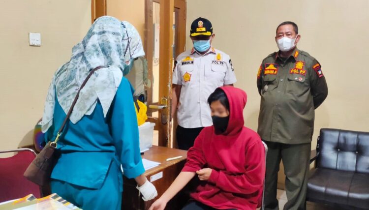 JALANI SCREENING—  SW (19), yang diamankan warga bersama dua teman prianya dalam pondok, menjalani screening di Mako Satpol PP dan akhirnya dibawa ke Panti Rehabilitasi Andam Dewi, 
Rabu (16/2).