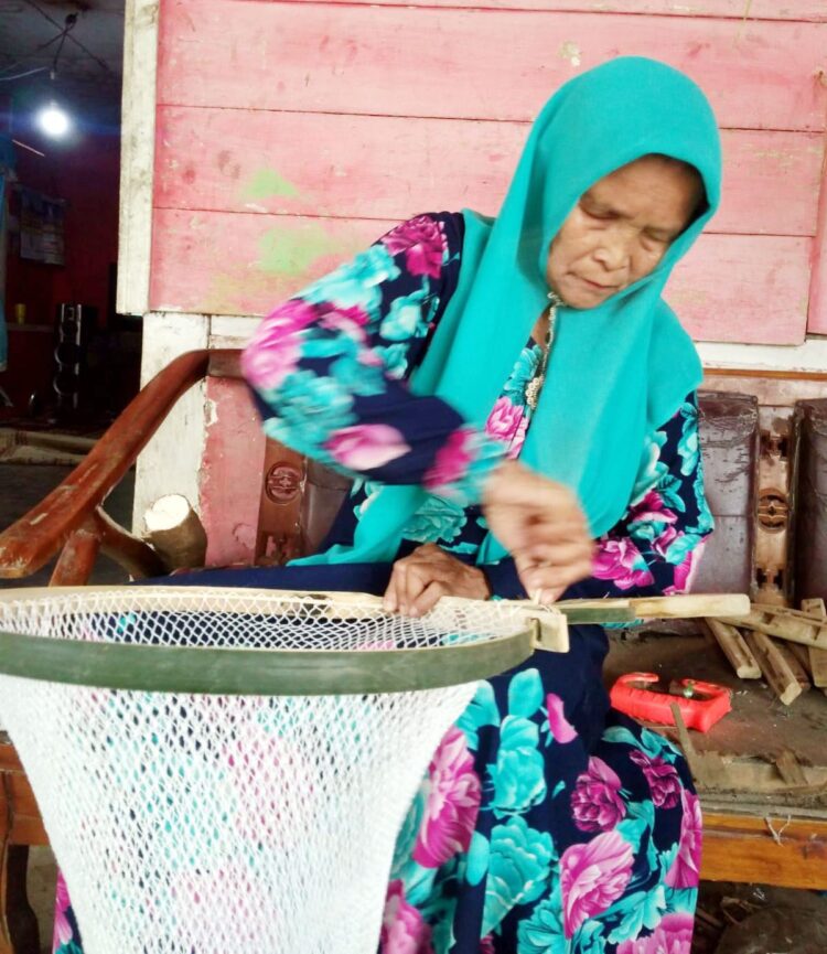 Merajut Tangguak 51 Tahun, Skill yang Diwariskan Turun Temurun 1 TANGGUAK— Pengrajin tangguak bernama Jusneti, saat membuat tangguak Ikan yang siap dipasarkan.