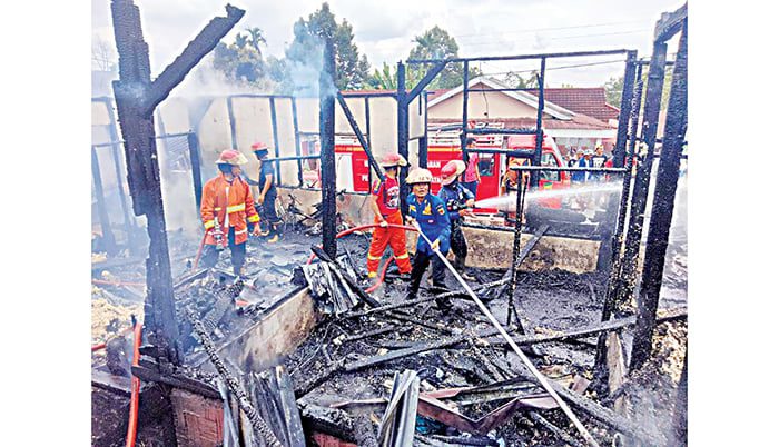 KEBAKARAN— Petugas Damkar sedang menyemprotkan air untuk memadamkan api yang membakar rumah dan warung di Nagari Lawang Mandahiling, Kecamatan Salimpaung.