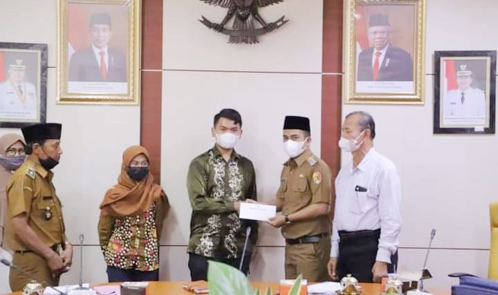 SERAHKAN--Wakil Walikota Solok Ramadhani Kirana Putra menyerahkan bantuan kepada Bambang dari Kelurahan Kampung Jawa yang diberangkatkan belajar ke Jerman.