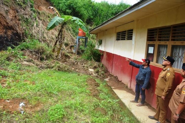 LONGSOR TEBING SEKOLAH — Wakil Bupati Tanahdatar  Richi Aprian saat meninjau  bekas longsor di SDN 12 Paninjauan.