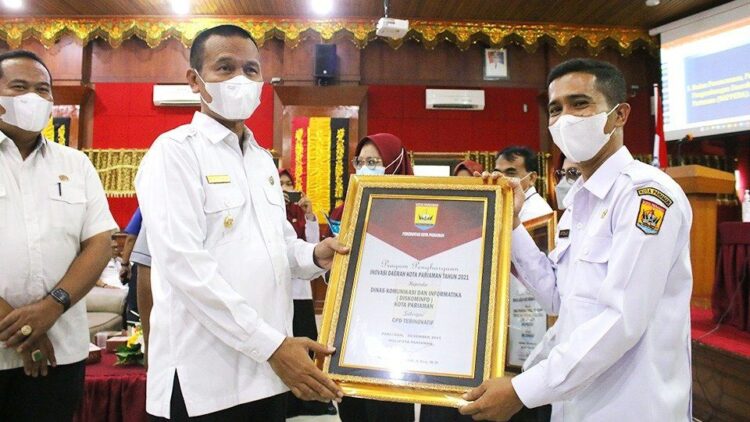 SERAHKAN PIAGAM—Wako  Genius Umar serahkan piagam kepada kadis Kominfo.