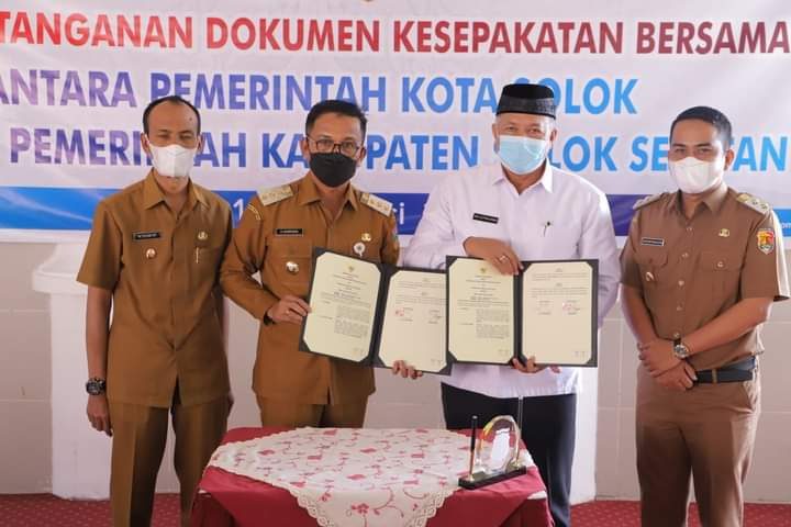 KONTRAK KERJA SAMA— Bupati Solok Selatan Khairunas memperlihatkan kontrak kerja sama dengan Kota Solok dalam melakukan kerjasama di berbagai bidang.