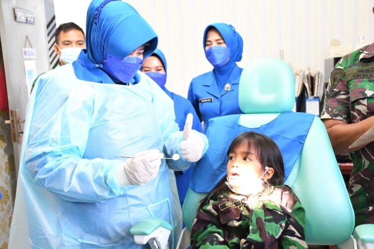 PERIKSA—Ketua Koordinator Cabang Korcab II Daerah Jalasenastri Armada DJA I Ny Amelia Endra Sulistiyono, periksa gigi murid TK Hangtuah.