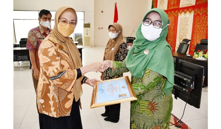 PENGHARGAAN— Wali Kota Padang diwakili Kepala DPMPTSP Kota Padang Corri Saidan menyerahkan piagam penghargaan kepada tiga OPD terbaik yang menciptakan inovasi sepanjang tahun 2021, Kamis (24/2).