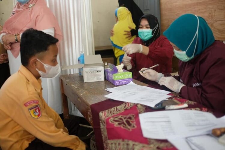 PERIKSA—Terlihat seorang anak menjalani pemeriksaan kesehatan sebelum disuntik vaksin.