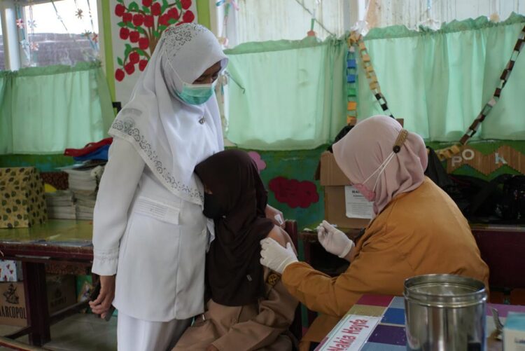 VAKSINASI ANAK-ANAK—Ditemani orang tua, seorang anak disuntik vaksin Covid-19 oleh tenaga kesehatan.