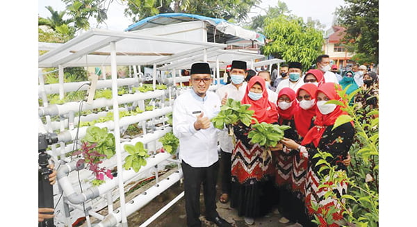 Usaha KWT Kelurahan di Kota Padang bisa jadi Industri Rumah Tangga 1 KELOMPOK WANITA TANI — Anggota KWT Cabe Rawit Asratek Kelurahan Ulak Karang Selatan berfoto bersama dengan Wako Padang Hendri Septa sembari memerlihatkan hasil tanaman yang sudah ditanam dan dipanen.