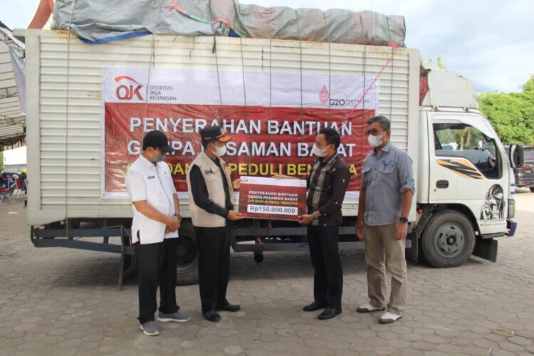 SERAHKAN BANTUAN — Kepala OJK Provinsi Sumbar, Yusri menyerahkan bantuan untuk korban gempa secara simbolis kepada Wakil Bupati Pasbar Risnawanto.