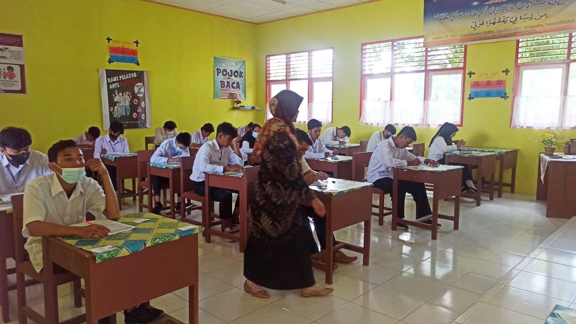 Pengolala sekolah Paket saat mengawasi peserta dalam ujian