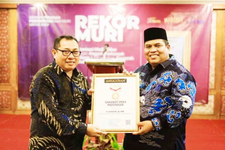 RAIH—Bupati Padangpariaman Suhatri Bur saat meraih penghargaan.