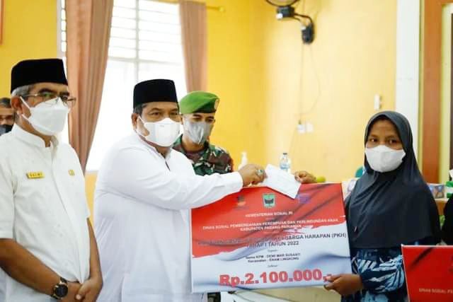 BAGIKAN BANTUAN—Bupati Padangpariaman Suhatri Bur saat membagikan PHK kepada warga.