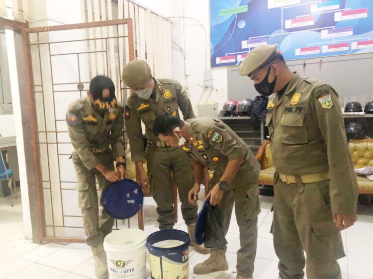 PERIKSA BB— Tim Sat Pol PP Kota Padangpanjang saat melaklukan pemeriksaan barang bukti tuak dalam ember.