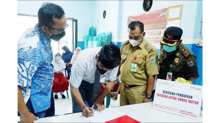 BERIKAN BEASISWA-Ketua Yayasan Astra Honda Motor, Ahmad Muhibbuddin (Kiri) bersama dengan Lurah Kelapa Gading Barat, H  Abdul Buang, mendampingi siswa pada proses penerimaan beasiswa.