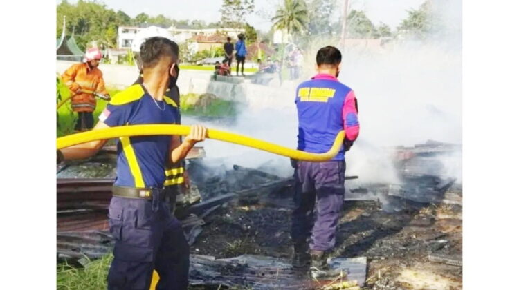 KEBAKARAN— Petugas Damkar menyemprotkan air untuk memadamkan api yang membakar gudang penyimpanan ikan di Pakan Kurai, Kecamatan Guguk Panjang, Kota Bukittinggi.