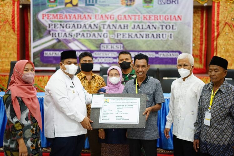 SERAHKAN UANG GANTI RUGI— Bupati Padangpariaman Suhatri Bur serahkan secara simbolis uang ganti kerugian pembebesan lahan jalan Tol kepada pemilik lahan.