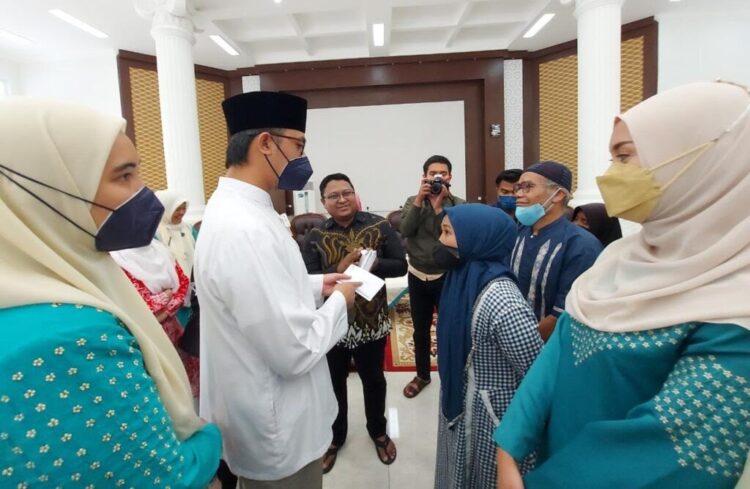 BANTUAN—Wali Kota Bukitttinggi Erman Safar menyerahkan bantuan kepada masyarakat untuk pelunasan utang kepada rentenir.