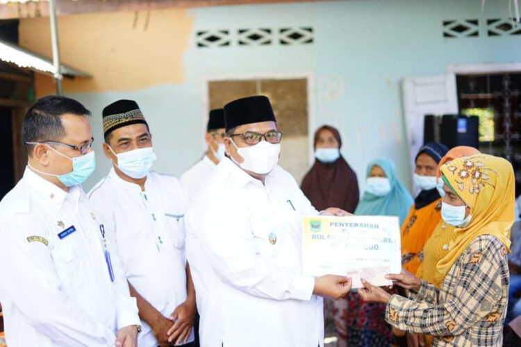 SERAHKAN BLT— Bupati Padangpariaman Suhatri Bur saat menyerahkan BLT kepada masyarakat.