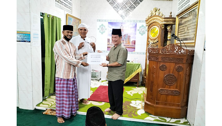 SERAHKAN BANTUAN— Anggota DPRD Kota Padang Osman Ayub, menyerahkan bantuan kepada pengurus Masjid Masjid Al Mujahidin RW IV, Kelurahan Kampung Olo, Kecamatan Nanggalo, Jumat (15/4) malam, saat kunjungan Safari Ramadhan.