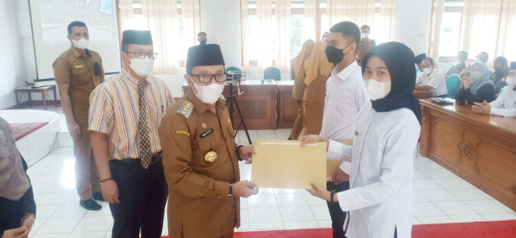 SAKSIKAN—Bupat Tanahdatar i Eka Putra disaksikan Sekda Iqbal Ramadi Payana serahkan SK CPNS pada perwakilan.