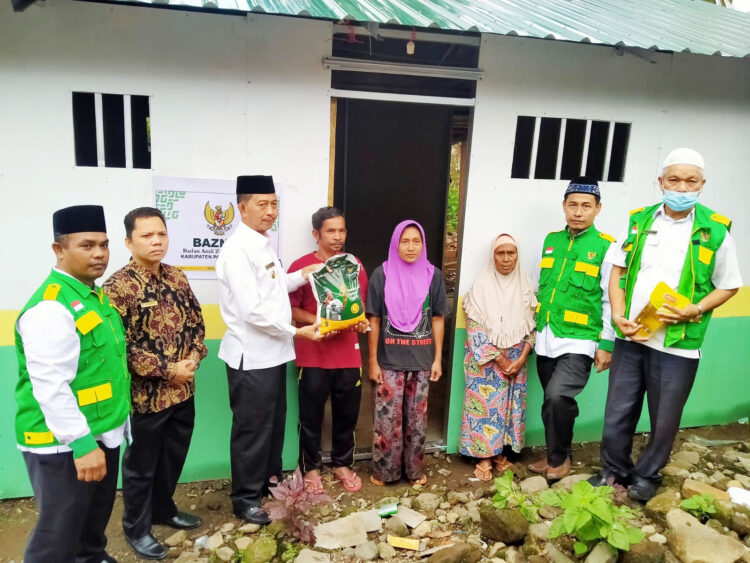 HUNIAN SEMENTARA— Wakil Bupati Pasbar Risnawanto menyerahkan kunci hunian sementara dan Paket Lebaran kepada warga korban gempa.