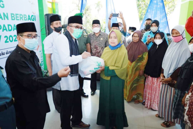 BERBAGI— Wali Kota Padang Hendri Septa menyerahkan paket sembako dalam program Baznas Padang berbagi dengan masyarakat tidak mampu.