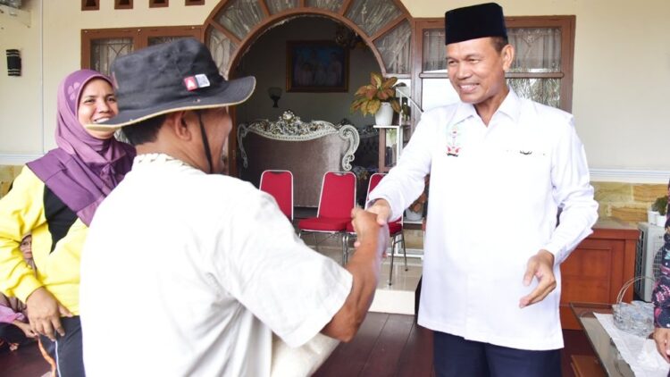 BANTUAN—Wali Kota Pariaman H  Genius Umar saat menyerahkan bantuan beras kepada seorang perwakilan petugas kebersihan.